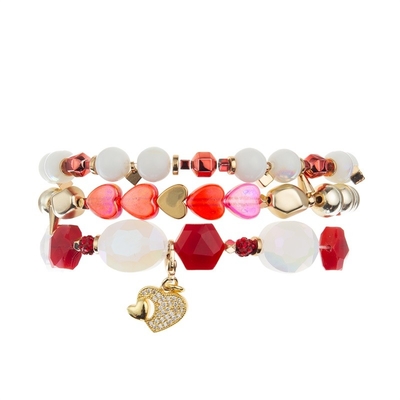 El metal del color oro gotea el corazón del rosa que la pulsera hecha a mano fijó para la muchacha como regalo