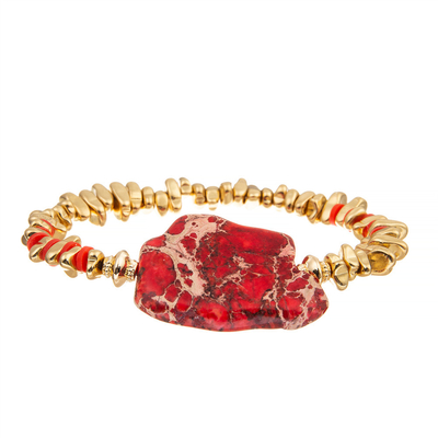 El oro de la pulsera plateó el brazalete de piedra machacado quebrado con la piedra irregular roja